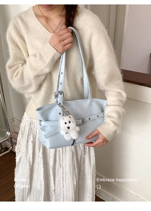 Gros plan du sac cabas bleu clair mat avec boucle élégante et breloque chien mignon