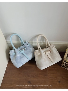 Close-up of vintage-style handbags featuring textured grid fabric and leather handles