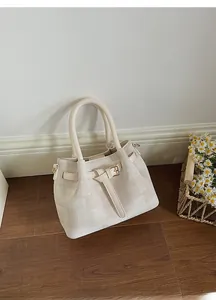 Detailed view of beige canvas handbag with check weave pattern and elegant bucket closure