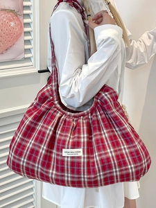Red plaid pleated shoulder bag with a spacious interior and soft fabric texture