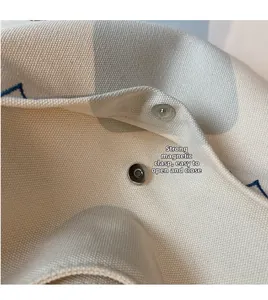 Close-up of powerful magnetic buckle for easy closure on white polka dot canvas bag