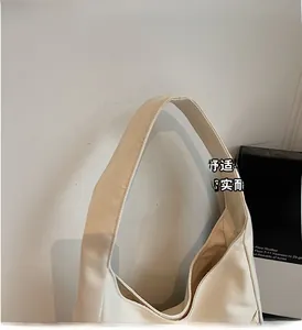 Detail of the reinforced wide shoulder strap on this minimalist beige canvas tote bag