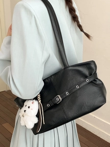 Sac fourre-tout minimaliste en cuir noir avec anneaux argentés et breloque chien peluche