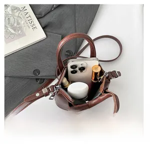 Internal view of mini brown leather bag showing storage space for phone and lipstick