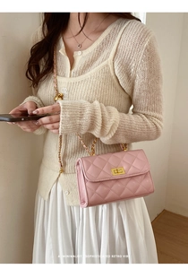 Detailansicht der rosa gesteppten Handtasche mit goldenem Drehverschluss und Kettenriemen