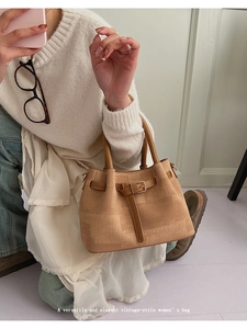 Close-up of vintage-style bucket bag in khaki fabric with brown leather straps