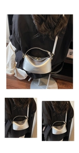 Detail view of the silver metallic crescent bag with top handle and crossbody strap