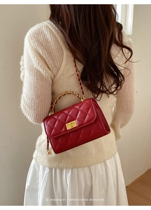 Rote Stepptasche mit goldener Kette auf der Schulter eines Models fotografiert