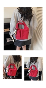 Détail du sac fourre-tout rouge en toile avec doubles poches et pendentif en peluche blanc