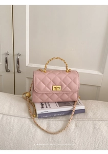 Detailansicht der rosa Stepptasche mit goldenem Drehverschluss und Kettenriemen