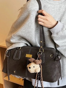 Brown suede tote bag with white contrast stitching and a cute bear charm pendant