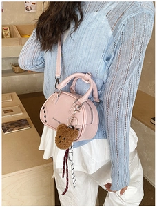 Sac à main rose à rivets avec pendentif ours porté sur une tenue de printemps