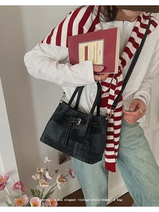 Detail of black vintage bucket bag with white contrast stitching and dual carry handles