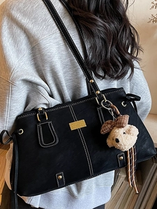 Classic black tote bag with white stitching and bear charm for professional women