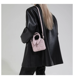 Mannequin portant un sac bandoulière rose style chemise avec un blazer en cuir noir
