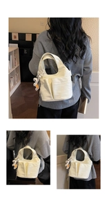 Détail du sac en toile crème avec plusieurs poches et un pendentif ours blanc mignon