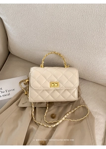 Detailansicht der cremeweißen Stepptasche mit goldener Kette und Drehverschluss