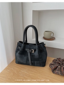 Close-up of vintage texture handbag with leather handles on a minimalist wooden table