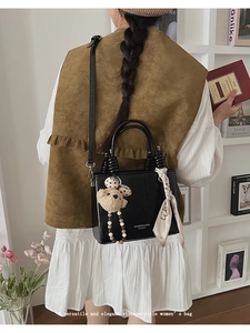 Retro black box bag with teddy bear pendant and silk scarf shown in a lifestyle setting