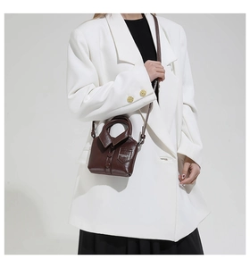 Détail d'un sac bandoulière créatif en forme de chemise en cuir PU marron foncé avec lanière