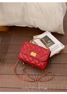 Detailansicht der roten Steppledertasche mit goldenem Drehverschluss und Kettenriemen