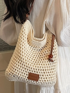 Minimalist beige crochet tote bag with brown leather handles and decorative wood beads