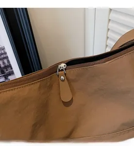 Detailed macro view of the smooth silver zipper and textured brown nylon fabric