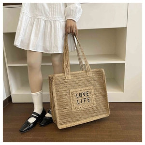 Vue détaillée du sac cabas beige tressé avec broderie LOVE LIFE noire de style bohème