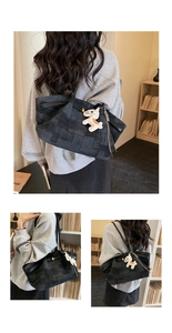 Detail of dark gray checkerboard tote bag with black leather straps and horse pendant