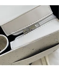 Detail of silver star prints on white leather with polished metal zipper puller