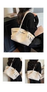 Close-up of beige tote bag with geometric texture, gold lock, and horse charm