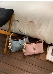 Detailed view of light blue and pink crossbody bags with flower and pompom charms