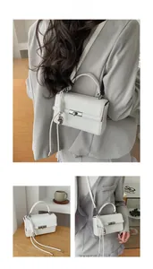 Detailansicht einer weißen minimalistischen Tasche mit Griff und Metallschnalle