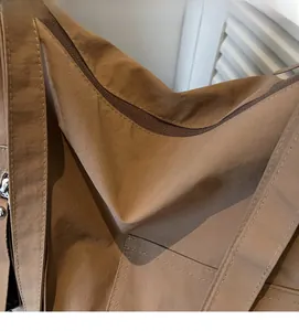 Detail shot of brown high-density nylon tote bag with reinforced stitching and zipper