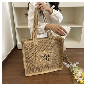 Détail du sac cabas en paille tissée avec broderie Love Life noire et des anses