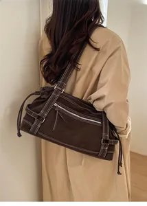 Detail view of brown canvas tote bag with contrast stitching and branded lettering