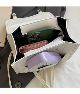 Top view of the spacious internal compartments in a white denim flap bag with star patterns