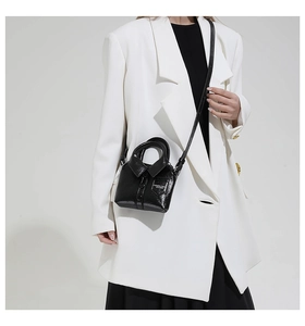 Détail du mini sac bandoulière noir en forme de chemise avec finition en cuir brillant