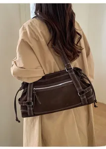 Detailed view of large brown faux suede tote bag with contrast stitching on shoulder
