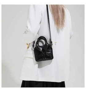 Détail d'un mini sac créatif en cuir noir en forme de chemise avec boutons et poche