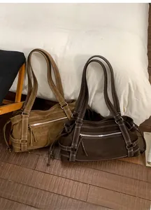 Close-up of vintage tote bags in brown and dark coffee with decorative white stitching