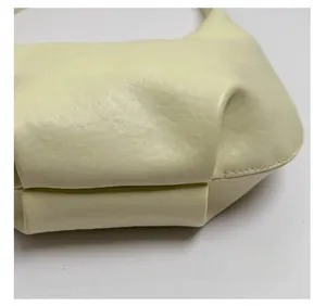 Detail shot of cream leather crescent bag showing fine stitching and premium texture