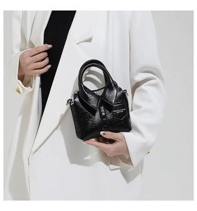 Détail d'un sac à main créatif en cuir noir en forme de chemise avec col et boucles en métal