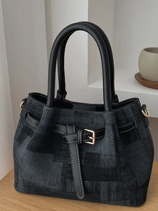 Elegant black jacquard bucket bag with leather handles and golden metal hardware details