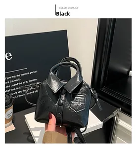 Détail du sac à main noir en forme de chemise avec finition brillante et boutons décoratifs