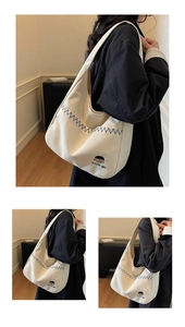 Detail view of cream canvas tote bag with blue zigzag stitching and cute girl embroidery