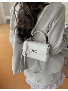 Rückansicht einer weißen Leder-Umhängetasche mit Silberverschluss und Quastendekor