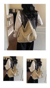 Detail view of large canvas crossbody bag with functional front pockets and adjustable strap