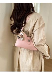 Pink hobo bag detail with litchi grain texture, silver lock and heart charm