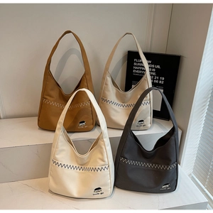 Detail showing four solid color canvas tote bags with horizontal stitched front pockets